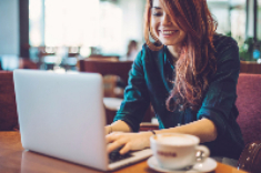 A woman using her laptop at a coffee shop.