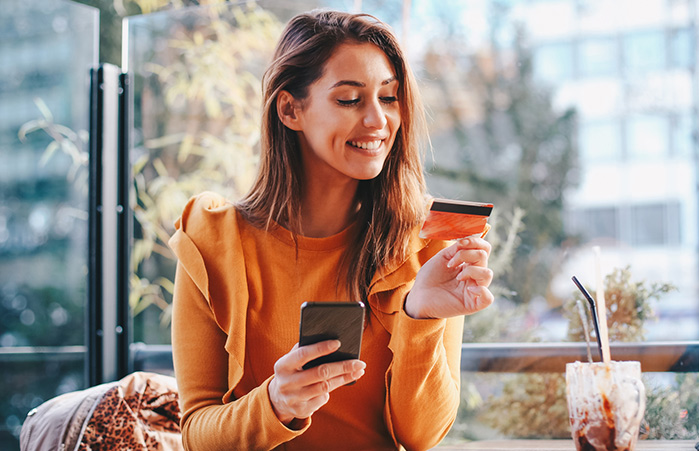 Person with credit card on phone.