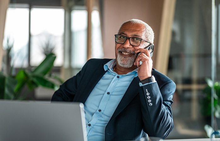 Business person on the phone in front of their laptop.