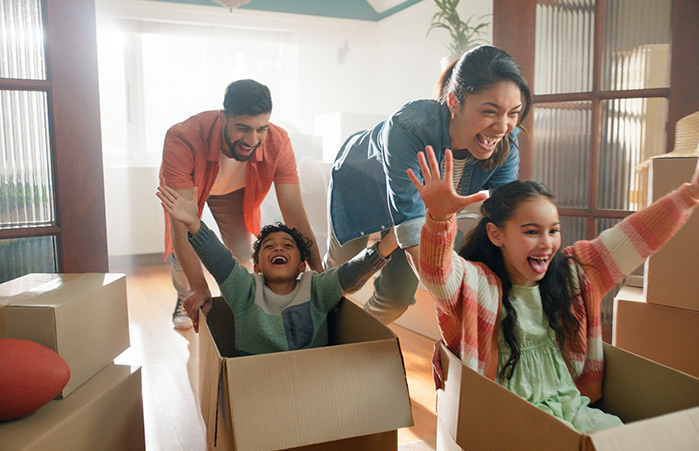 Family playing with boxes in their new home.